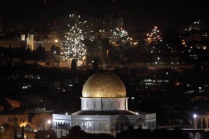 The golden dome of the Dome of the Rock, Islam's third holiest place and part of the al-Aqsa Mosque complex, is seen as fireworks light the skies of Jerusalem to mark the new year on January 1, 2013. AFP PHOTO/AHMAD GHARABLI
